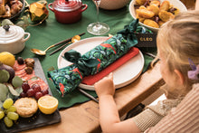 Load image into Gallery viewer, A little girl points at her personalised Christmas cracker on the Christmas table
